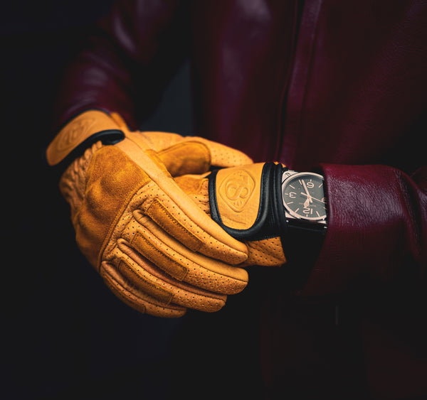 Luxury leather motorcycle gloves with yellow suede and perforated leather with knuckle protection covered in Suede with a luxury watch
