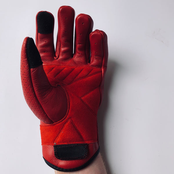 A pair of Seraph motorcycle gloves by 78 Motor Co., featuring a mix of red leather and suede with black accents on the knuckles and a velcro strap on the wrist.