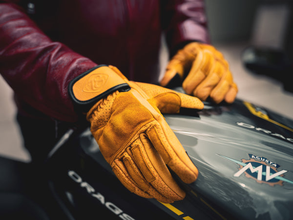 Luxury leather motorcycle gloves with yellow suede details with an MV Agusta motorcycle