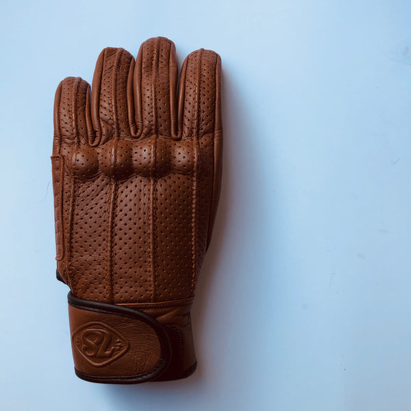 A Speed motorcycle glove by 78 Motor Co., made of brown perforated leather with knuckle protection and a velcro strap on the wrist with the number '78' embossed on the strap.